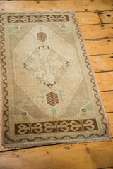 Oushak rug mat corner with coffee brown zig-zag border, geometric motifs, and fringe.
