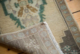 Hand-knotted foundation and short fringe of a vintage Oushak rug, with beige and green pile.