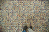 Distressed Oushak rug with faded ivory, sky blue, blush, and terra cotta henna motifs.