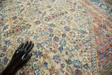 Distressed Oushak rug texture with intricate henna plant patterns in sky blue, blush, and ivory.