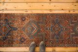 Close-up of traditional Persian Karaja gul motif in brick red, navy, and teal.