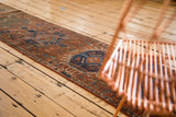 Traditional Karaja runner displaying repeating single column gul motifs in brick red, navy, and teal.