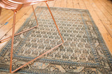 Vintage Mir Sarouk rug close-up: ivory field, charcoal and peach motifs, geometric sky blue border.