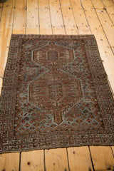 Vintage Shiraz rug corner with geometric border details in chestnut, slate blue, and rust.