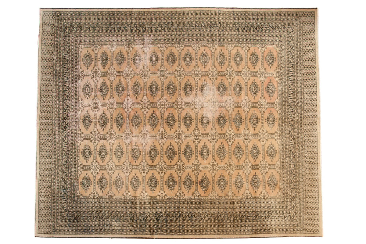 Distressed vintage Pakistani carpet in blanched pink ivory with dark Turkmen geometric pattern.