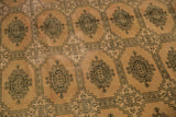 Blanched pink ivory field, intricate Turkmen geometric motifs on this distressed hand-knotted carpet.
