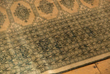 Distressed geometric patterns and Turkmen motifs on blanched pink ivory vintage Pakistan rug.