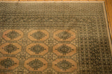 Turkmen geometric patterns on blanched pink ivory, distressed vintage Pakistan carpet corner.