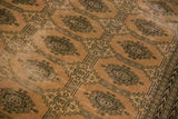 Textured blanched pink ivory vintage Pakistan carpet with dark geometric Turkmen motifs.