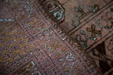 Distressed Dualatabad rug, close-up of textured pile in dusty blush, charcoal, and blue.