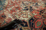 Distressed vintage Heriz rug's geometric pattern in cherry red and sapphire blue.