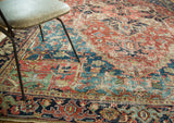 Detailed view of distressed Heriz carpet pile, showcasing cherry red, navy, and mallard green.