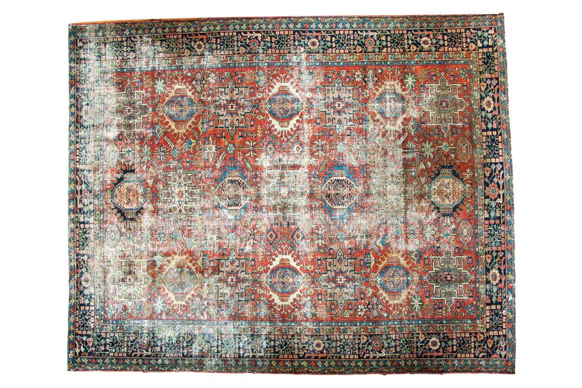 Distressed vintage Karaja carpet with repeating multi-medallion pattern in rich jewel tones.