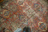Distressed Karaja carpet with repeating geometric medallions in brick red, aqua, and sand.