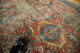 Textured detail of distressed Karaja rug showing geometric medallions in brick red, aqua, saffron.