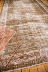 Distressed vintage Mahal carpet showing sage green field, ivory fading, and red patterned border.