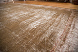 Distressed vintage Mahal carpet, showing exposed white foundation, faded sage green, and red border.