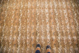 Distressed vintage Persian Qom carpet, muted allover channels of botehs and vines, feet for scale.