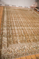 Distressed Qom rug's antique ivory border with floral motifs and faded field's meandering vines, botehs.