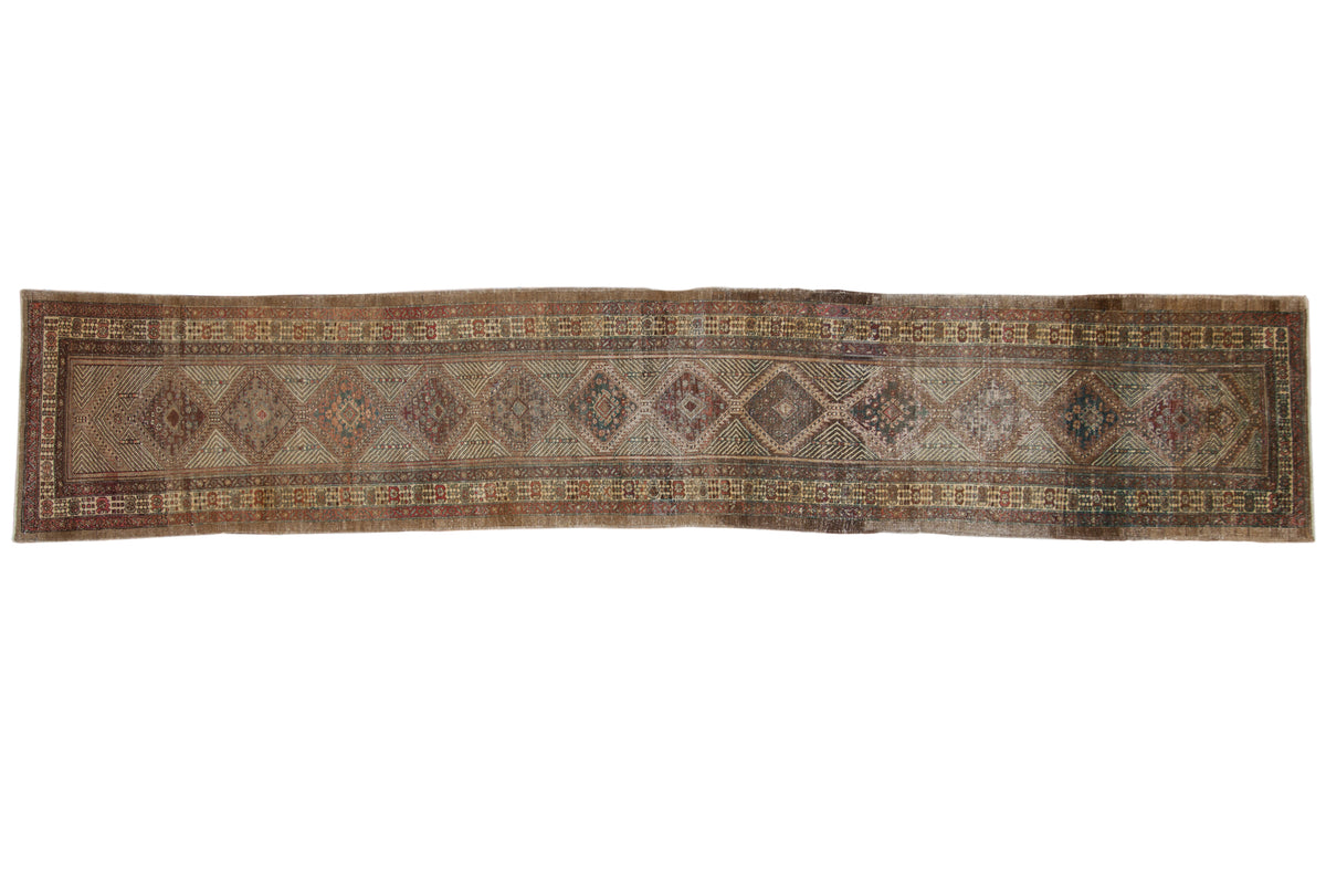 Vintage Persian hand-knotted Serab runner with repeating geometric diamond medallions in antiqued tones.