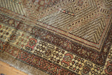 Hand-knotted Serab rug detail showcasing geometric borders in camel hair, gold, and copper.