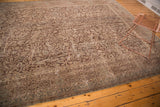 Ornate distressed Turkish Oushak carpet featuring scrolling arabesques and exposed foundation.