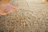 Decorative distressed Oushak rug with faded scrolling floral tendrils.