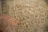 Distressed vintage Oushak carpet showcasing faded beige, blue, and terracotta floral tendrils.