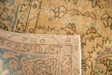 Folded Distressed Vintage Oushak carpet, revealing muted floral pile and hand-knotted foundation.