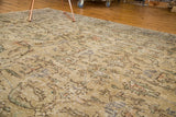 Detail of distressed vintage Oushak rug showing muted beige pile with faded floral patterns.