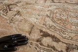 Distressed Oushak carpet texture with faded apricot, celadon, and chocolate brown vinery.
