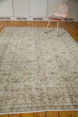 Faded scrolling floral vines and tendrils on a distressed vintage Oushak rug.