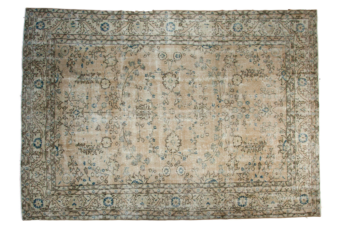 Distressed Vintage Oushak carpet, allover faded floral motifs in ivory, blue, and brown, 7'1" x 10'.