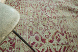 Distressed Oushak rug with intricate lattice pearl and cloud band patterns in ivory, raspberry, caramel.