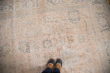 Faded pink ivory and slate blue floral motifs on a distressed vintage Oushak.