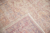 Distressed Oushak rug corner, showing ballerina pink, lavender, fuchsia border, and fringe.