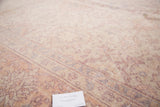 Distressed vintage Oushak carpet pile showing faded cream, pink, and lavender floral patterns.