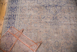 Distressed beige field and violet purple border of a vintage Turkish Oushak rug.