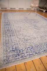Distressed vintage Oushak carpet, worn texture, beige field, and violet main border.