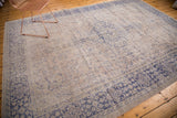 Distressed beige field and unusual vibrant violet border on hand-knotted Oushak rug.
