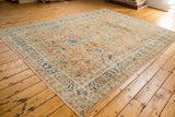 Corner of distressed Oushak carpet, blue elongated botehs on peach floral field.