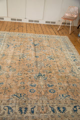 Decorative distressed texture on vintage Oushak rug with blue floral palmettes and boteh motifs.