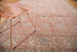 Faded crevette pink and ivory patterns with seaglass accents on a distressed vintage Oushak rug.