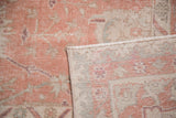 Hand knotted Oushak rug detail: faded crevette pink pile with ivory, blue, and woven back.