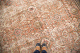 Distressed traditional Persian Mahal carpet, terra-cotta, cream, blue-gray, feet for scale.
