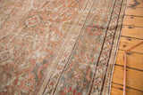Distressed texture on the hand-knotted Mahal rug border with terra-cotta, blue-gray, and green.