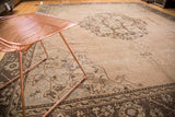 Textured pink-brown field of distressed Oushak rug, prominent curvilinear medallion and slate silver border.
