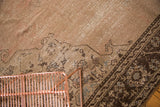 Distressed Turkish Oushak carpet with worn pink-beige field and dark brown border, slate silver motifs.