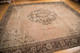 Distressed pink-brown Oushak rug corner, showing foundation wear and slate silver border.