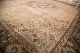 Corner detail of distressed vintage Oushak rug, pink-beige field with slate silver motifs.